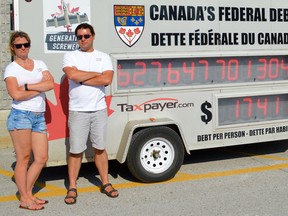 Ontario director Christine Van Geyn and federal director Aaron Wudrick of the Canadian Taxpayers Federation stand beside the Federation?s debt clock, during a recent visit to Petrolia. Melissa Schilz/Postmedia Network