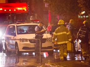 Police and fireman work at the rear of an auditorium where a gunman shot and killed one person during the PQ victory rally on September 5, 2012 in Montreal. The trial of Richard Henry Bain, charged in connection with Quebec's 2012 election-night shooting, has resumed. THE CANADIAN PRESS/Paul Chiasson