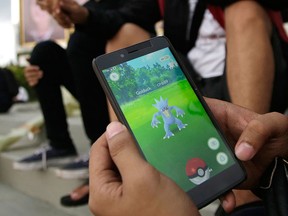 In this Monday, July 18, 2016 photo, an Indonesian man shows his smartphone as he plays "Pokemon Go" in Jakarta, Indonesia. (AP Photo/Tatan Syuflana)