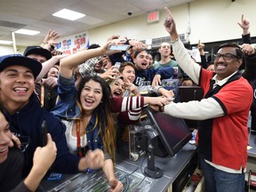 This Jan. 13, 2016 file photo shows 7-Eleven store clerk M. Faroqui celebrates with customers after learning the store sold a winning Powerball ticket in Chino Hills, Calif. The California lottery said Tuesday, July 19, 2016, a couple, Marvin and Mae Acosta, have claimed a $528.8 million share of a record record $1.6 billion Powerball jackpot in January. (Will Lester/The Sun via AP, File)