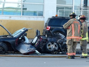 Firefighters look over the wreckage of a Porsche that lost control on Queen's Quay near Parliament and crashed into a building and parked car, and then caught fire July 2, 2016. (John Hanley/Postmedia Network)
