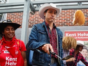 Prime Minister Justin Trudeau, centre, flips flapjacks at a Stampede breakfast in Calgary, Alta., Saturday, July 16, 2016.THE CANADIAN PRESS/Jeff McIntosh