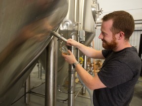 Gavin Anderson of Anderson Craft Ales taps a sample of his first brew at their Elias Street location in London. (MIKE HENSEN, The London Free Press)