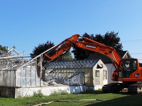 The greenhouses behind the Backyard Flower Shop being knocked down. (Justine Alkema/Clinton News Record)