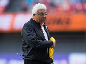 Lions head coach Wally Buono carries a challenge flag after throwing it during the first half of a pre-season game against the Stampeders in Vancouver on June 17, 2016. (Darryl Dyck/The Canadian Press)