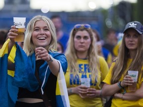 A Sweden fan smiles with a beer as she watches the Euro 2016 group E football match between Sweden and Belgium June 22, 2016. (AFP PHOTO / GEOFFROY VAN DER HASSELT)
