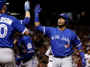 Toronto Blue Jays' Edwin Encarnacion high fives teammates after hitting a three-run home run against the Arizona Diamondbacks during the third inning of an interleague baseball game in Phoenix on July 19, 2016. (AP Photo/Matt York)