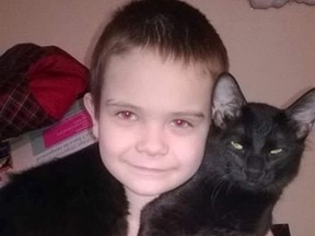 Photo supplied
Zac Morin holds his buddy Shadow. The cat was found fatally wounded last week outside the family’s home on Fairview Avenue.