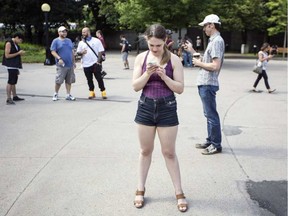 Leanne Sharzer, centre, was one of a few hundred people gathered for a Pokemon Go Lure Party in Confederation Park Tuesday, July 19, 2016. Darren Brown/Postmedia