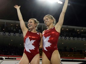 Canada's Rosie MacLennan (left) and Karen Cockburn (right) wave to the crowd during the women's trampoline competition at the Pan Am Games in Toronto on July 19, 2015. MacLennan will defend her Olympic gold medal at the Rio Olympic Games next month. (Gregory Bull/AP Photo/Files)