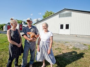 RebuiltJanet, Hank John and Susi Reinink stand in front of their newly finished rebuilt chicken barn in Yarker, Ont. on Monday, July 18, 2016. Six months ago one of their three barns burned to the ground. Now they're ready to move chickens into the newly-completed structure and get back to marketing their organic, free range eggs. Meghan Balogh/Napanee Guide/Postmedia Network