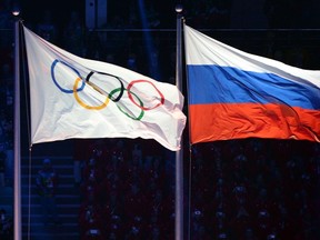 This file photo taken on Feb. 7, 2014 shows the Olympic and Russian flags during the Opening Ceremony of the Sochi Winter Olympics at the Fisht Olympic Stadium. (AFP PHOTO/YURI KADOBNOVYURI)