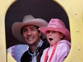 Prime Minister Justin Trudeau enjoys a ride with daughter Ella-Grace at the Calgary Stampede in Calgary on July 15, 2016. (Leah Hennel/Postmedia Network)