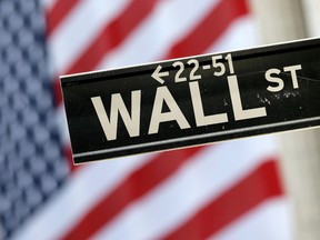 In this Tuesday, Sept. 8, 2015, file photo, a Wall Street street sign is framed by an American flag hanging on the facade of the New York Stock Exchange. (AP Photo/Mary Altaffer, File)