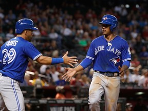 Marcus Stroman of the Toronto Blue Jays (right) celebrates with teammate Devon Travis after scoring against the Arizona Diamondbacks during the sixth inning of the MLB game at Chase Field on July 20, 2016 in Phoenix, Ariz. (CHRISTIAN PETERSEN/Getty Images)