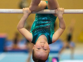 MaKenzie Wilson, 7, a  young gymnast from the Forest City Gymnastics club in London practices on the uneven bars. The club wants to move to a new, bigger location.  Mike Hensen/The London Free Press/Postmedia Network