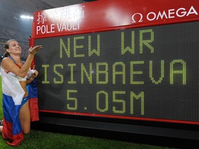 Russia's Yelena Isinbayeva poses next to a scoreboard after setting a new world record to win gold in the women's pole vault final during the athletics competitions at the Beijing 2008 Olympics on Aug. 18, 2008. Russia lost its appeal Thursday, July 21, 2016 against the Olympic ban on its track and field athletes, a decision which could add pressure on the IOC to exclude the country entirely from next month's games in Rio de Janeiro. (Thomas Kienzle/AP Photo/Files)