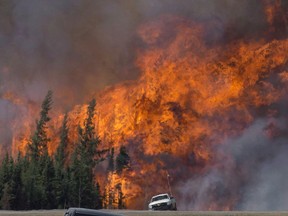 A giant fireball is seen as a wildfire rips through the forest 16 kilometres south of Fort McMurray, Alta., on Highway 63 Saturday, May 7, 2016.  THE CANADIAN PRESS/Jonathan Hayward
