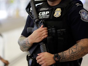A U.S. Customs and Border Protection officer patrols outside of the departures area at Miami International Airport, Friday, July 1, 2016, in Miami.  (AP Photo/Lynne Sladky)