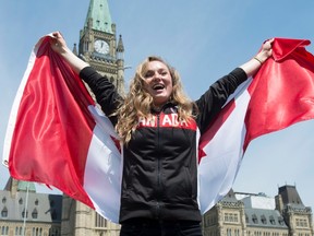 Canadian gymnast Rosie MacLennan holds a Canadian flag after being named as the flag-bearer for the upcoming Summer Olympics in Rio de Janeiro in Ottawa on Thursday, July 21, 2016. (Adrian Wyld/The Canadian Press)