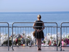 A woman stands by the new makeshift memorial in tribute to the victims of the deadly Bastille Day attack at the Promenade des Anglais on July 19, 2016 in Nice, after it was moved from the pavement of the road to the seafront so that the street can be re-opened. (AFP PHOTO / Valery HACHEVALERY HACHE/AFP/Getty Images)