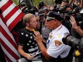 A Cleveland police officer speaks with a protester on Cleveland Public Square on the final day of the Republican National Convention on July 21, 2016, in Cleveland, Ohio. / AFP PHOTO / DOMINICK REUTERDOMINICK REUTER/AFP/Getty Images