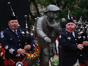 Firefighter pipe band members march by the Firefighters Memorial in Toronto. Patrick Pidgeon, who died battling an apartment fire in Amherstview last weekend, will have his name added to the memorial. (Craig Robertson/Postmedia Network)