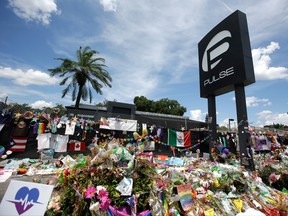 This photo taken July 11, 2016, shows a makeshift memorial continuing to grow outside the Pulse nightclub, the day before the one month anniversary of a mass shooting,  in Orlando, Fla.  The reports from about a dozen deputies released late Thursday, July 21, 2016, by the Orange County Sheriff's Office raise some new questions, answer some older ones and show the horror of the worst mass shooting in recent U.S. history. (AP Photo/John Raoux)