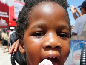 Three year old Robin Esin of Ajax enjoys a cooling cone at free community weekend at the Rogers Cup in Toronto on Saturday July 23, 2016. Michael Peake/Toronto Sun/Postmedia Network