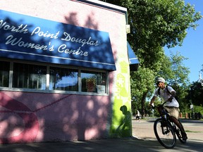 A cyclist passes the North Point Douglas Women's Centre on Austin Street North in Winnipeg on Fri., July 22, 2016. Kevin King/Winnipeg Sun/Postmedia Network