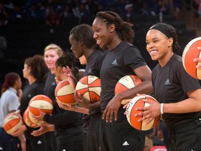 Members of the New York Liberty basketball team await the start of a game against the Atlanta Dream in New York on July 13, 2016. The WNBA is withdrawing its fines against the Liberty, Phoenix Mercury and Indiana Fever and their players for wearing plain black warm-up shirts in the wake of recent shootings by and against police officers. (Mark Lennihan/AP Photo/Files)