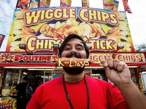 Edmonton Postmedia reporter Ameya Charnalia tries a lobster corn dog at K-Days in Edmonton, Alta., on Saturday, July 23, 2016.