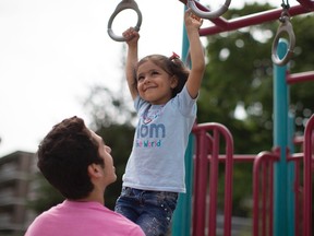 A young Syrian refugee is helped on the hoops of a playground activity while attending H.appi camp in Toronto on Tuesday July 12 , 2016. The day camp is geared to helping Syrian refugee youth acclimate to Canadian life and get ready for school. THE CANADIAN PRESS/Chris Young