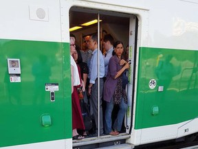GO Transit users are forced to stand in the doorway of a train. Commuters are complaining about overcrowding on the Lakeshore line. (Supplied)