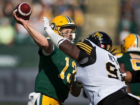 Mike Reilly, shown here just before absorbing a hit from Ticats DT Drake Nevis on Saturday, says he didn't get the ball out of his hands quickly enough during the second half of the game. (Greg Southam)