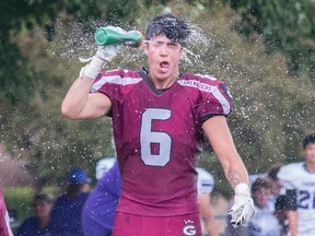 Receiver Nikolas Daniele-Reyes of the Limestone District Grenadiers squirts water into his face during a water break in the first half of an Ontario Varsity Football League senior varsity conference semifinal game Saturday, July 23, at Loyalist Collegiate. (Tim Gordanier/The Whig-Standard file photo)