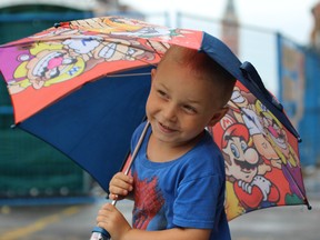 Samantha Reed/The Intelligencer
4-year-old Tyson Moore of Trenton plays with his umbrella on North Front street Monday morning. Monday's rain shower was welcomed by many local residents as the area is in need of some rainfall after weeks of heat.