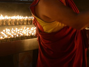 A Nepalese Buddhist monk performs rituals after lighting oil lamps in Kathmandu on May 21, 2016, during Buddha Purnima, which marks the Buddha's birthday. AFP PHOTO / PRAKASH MATHEMA