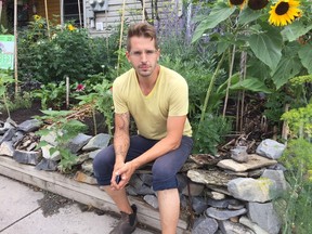 Sean Field, sitting in front of his home garden on Patrick Street, is challenging the city's bylaw on outdoor watering. He believes food gardens should not fall under the same restrictions as lawn watering and car washing.