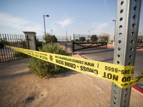 Police tape hangs at Gary Reese Freedom Park, where police say a shooting erupted when a man in a vehicle attempted to rob a group of people playing "Pokemon Go" early Monday, July 25, 2016, in Las Vegas. According to police, a player and the suspect shot each other and both men have non-life threatening injuries. (Brett Le Blanc/Las Vegas Review-Journal via AP)
