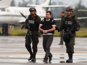 In this Tuesday July 9, 2013 file photo, Daniel Barrera, center, is escorted by police to a waiting car prior to his extradition to the U.S. from the counter-narcotics base in Bogota, Colombia. Known as "El Loco," Spanish for "The Madman," Barrera is scheduled to be sentenced Mondauy, July 25, 2016, and faces a mandatory minimum of 10 years in prison and up to life after pleading guilty to a drug trafficking charge. (AP Photo/Fernando Vergara, File)