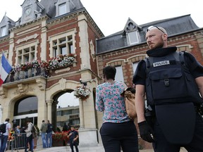A French police officer stands guard by Saint-Etienne-du-Rouvray's city hall following a hostage-taking at a church in Saint-Etienne-du-Rouvray, northern France, on July 26, 2016 that left the priest dead. (CHARLY TRIBALLEAUCHARLY TRIBALLEAU/AFP/Getty Images)