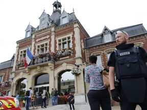 A French police officer stands guard by Saint-Etienne-du-Rouvray's city hall following a hostage-taking at a church in Saint-Etienne-du-Rouvray, northern France, on July 26, 2016 that left the priest dead. (CHARLY TRIBALLEAU/AFP/Getty Images)