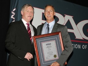 Bruce Chapman from the Police Association of Ontario, left, presents CKPS Constable Pete Bakker with the John Walker Award May 18.