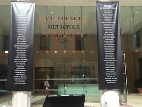 The names of the victims of truck attack in Nice, that killed 84 people last Thursday hang from two pillars at Nice City Hall in Nice, France Friday July 22, 2016. (AP Photo/Maeva Bambuck)