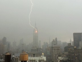 In this Monday, July 25, 2016 frame from video provided by Henrik Moltke, lightning strikes the Empire State Building during a storm in New York. Moltke said he saw the storm approaching from his office window and captured the strike by balancing his phone against the glass. (Henrik Moltke via AP)