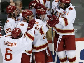 Denver forward Trevor Moore, right, jumps on Denver defenceman Blake Hillman (25) as they celebrate with teammates after Hillman scored on Ferris State goalie Darren Smith during the third period of an NCAA men's hockey West Regional championship in St. Paul, Minn., Sunday, March 27, 2016. Denver won 6-3. (AP Photo/Ann Heisenfelt)