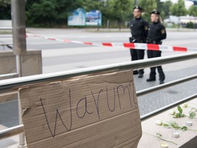 A sign reading "why" is fixed where a shooting took place in front of a fast food restaurant leaving nine people dead the day before on Saturday, July 23, 2016 in Munich, Germany. (AP Photo/Sebastian Widmann)