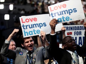 Delegates hold up signs that read "Love trumps hate" during the opening of the first day of the Democratic National Convention at the Wells Fargo Center, July 25, 2016 in Philadelphia, Pennsylvania. An estimated 50,000 people are expected in Philadelphia, including hundreds of protesters and members of the media. The four-day Democratic National Convention kicked off July 25.  (Photo by Drew Angerer/Getty Images)
