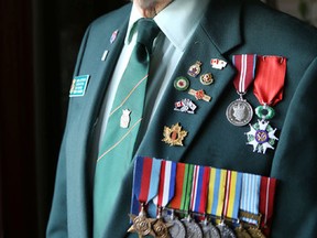 Tony Elliott wears the Legion of Honour Medal in his home in Amherstview on Tuesday. The medal is France's highest order of merit. (Elliot Ferguson/The Whig-Standard/)